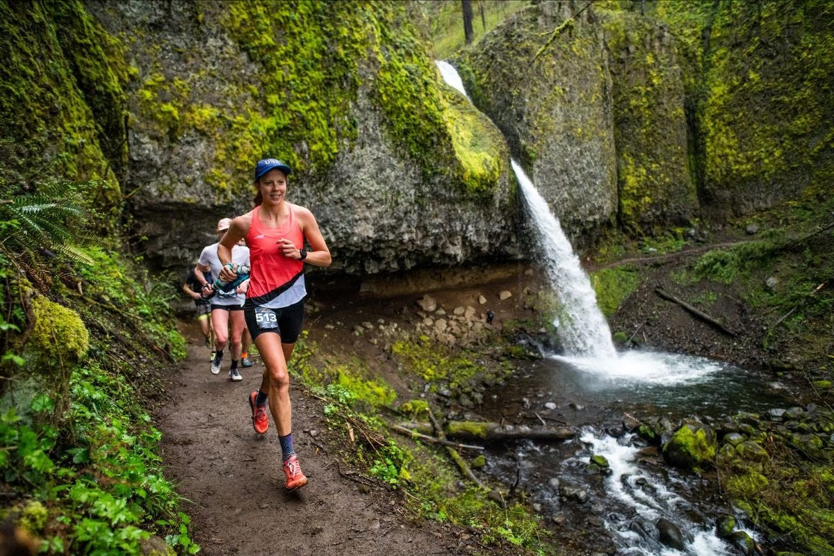 woman trail running in forest