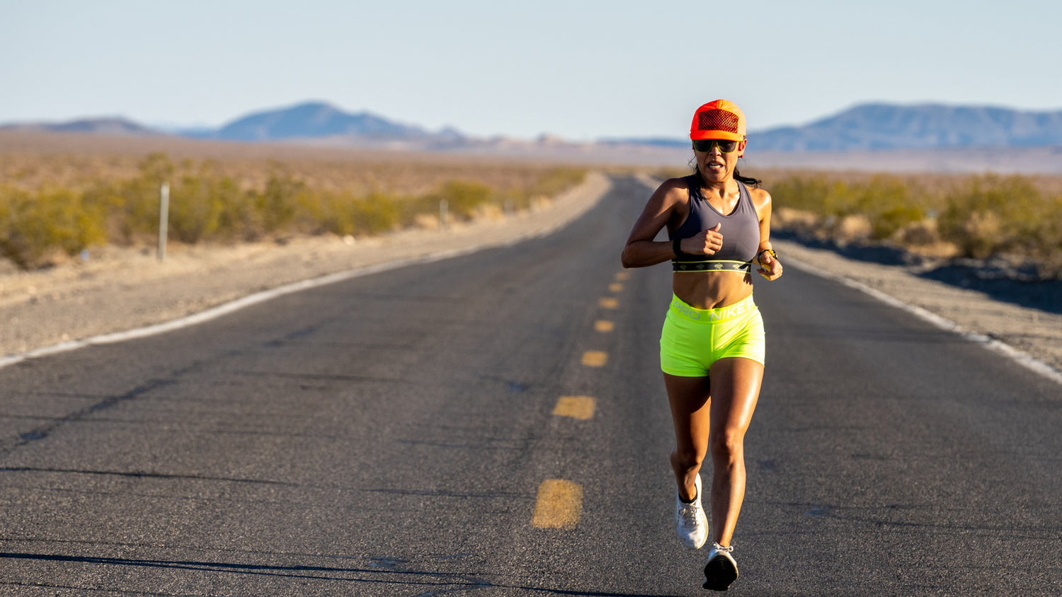 woman running on a road in the middle of the desert