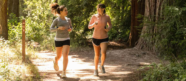 Endurance athletes running on a trail in the woods