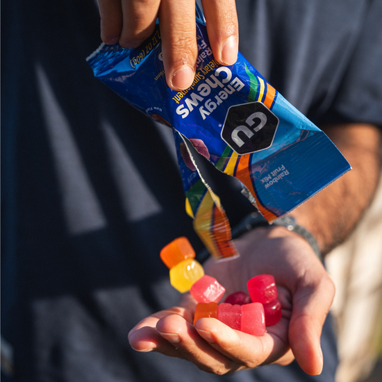 Rainbow Fruit Mix Energy Chews pouring out of the bag into a hand