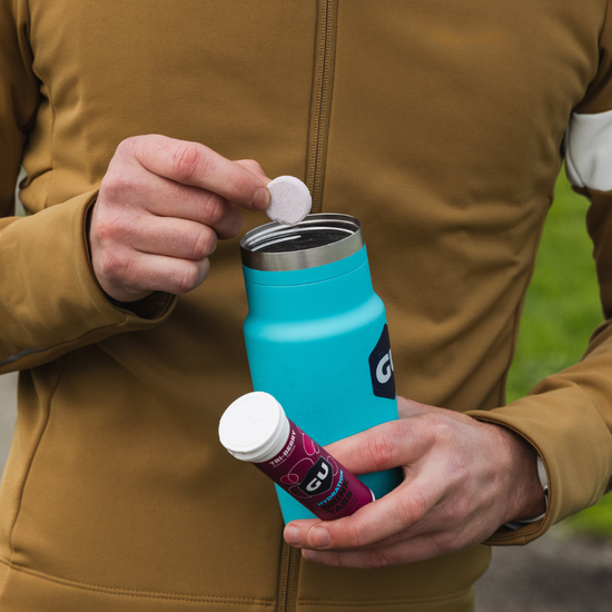 person putting GU tri-berry hydration tablet into a GU Bivo bottle